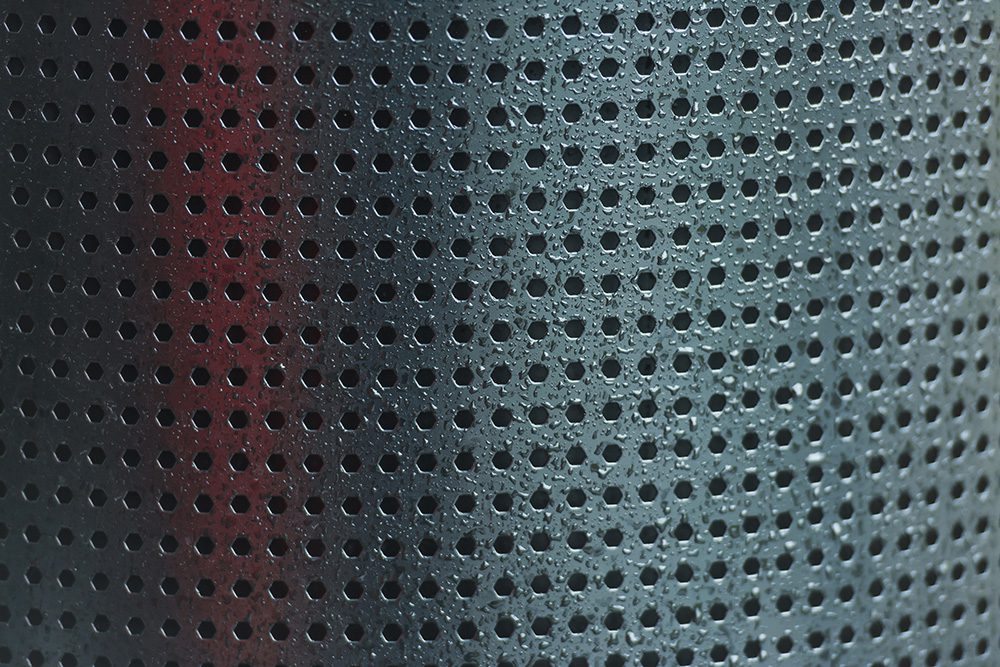 Water droplets on a metal strainer basket.